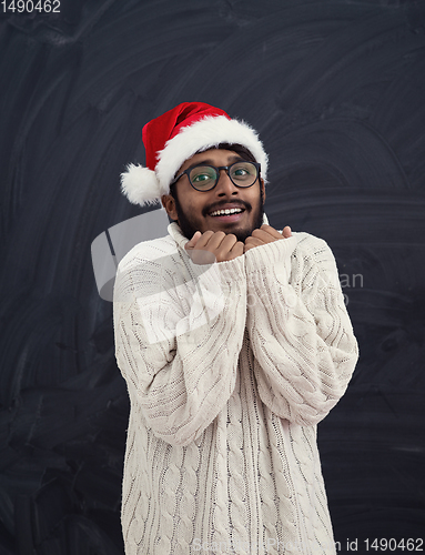 Image of Indian man wearing traditional Santa  hat  and white sweater