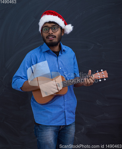 Image of Santa playing Latin America traditional small guitar