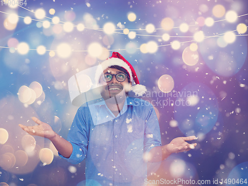 Image of Indian man wearing traditional Santa Claus hat