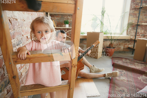 Image of Young father and his daughter moved to a new house or apartment