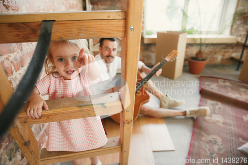 Image of Young father and his daughter moved to a new house or apartment