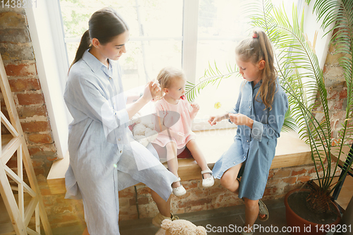 Image of Young mother and her daughters moved to a new house or apartment