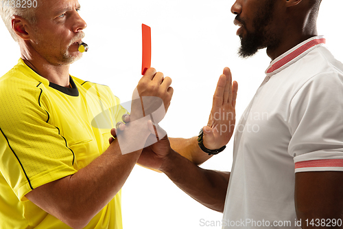 Image of Football referee showing a red card to a displeased player isolated on white background