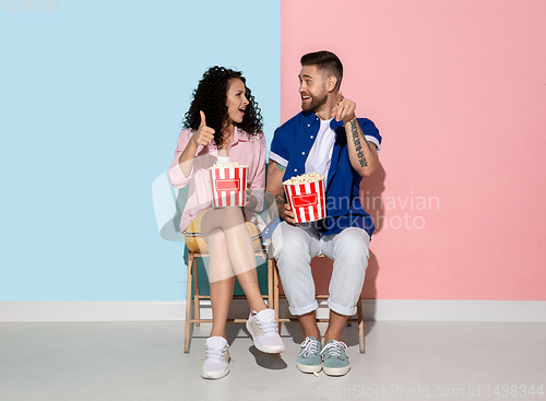 Image of Young emotional man and woman on pink and blue background