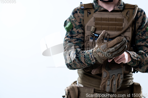 Image of closeup of soldier hands putting protective battle gloves