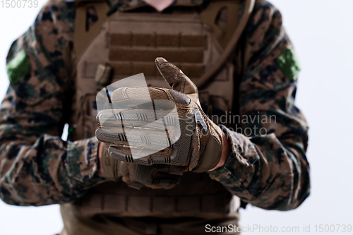 Image of closeup of soldier hands putting protective battle gloves