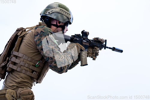 Image of soldier in action aiming laseer sight optics