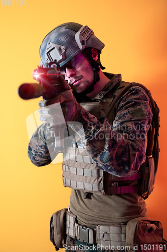 Image of soldier in action aiming laseer sight optics yellow background