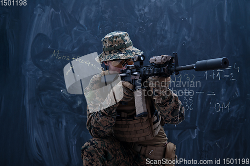 Image of soldier in action aiming laseer sight optics