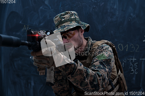 Image of soldier in action aiming laseer sight optics