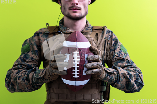 Image of solder holding american football ball