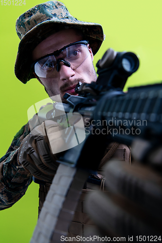 Image of soldier in action aiming laseer sight optics green background