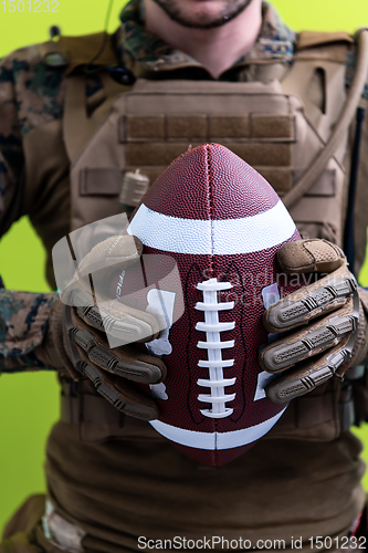 Image of solder holding american football ball