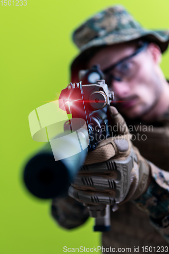 Image of soldier in action aiming laseer sight optics green background