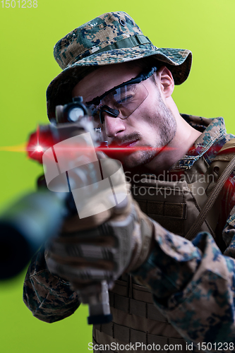 Image of soldier in action aiming laseer sight optics green background