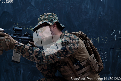 Image of soldier in action aiming laseer sight optics