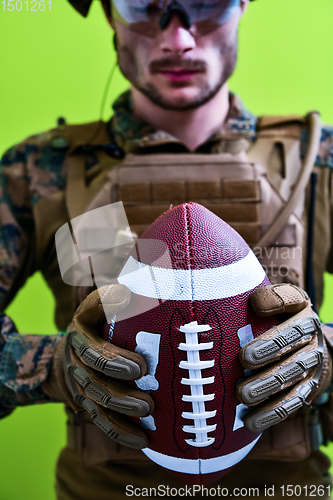 Image of solder holding american football ball