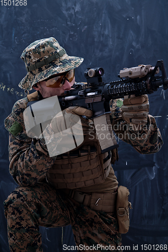 Image of soldier in action aiming laseer sight optics