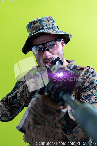 Image of soldier in action aiming laseer sight optics green background