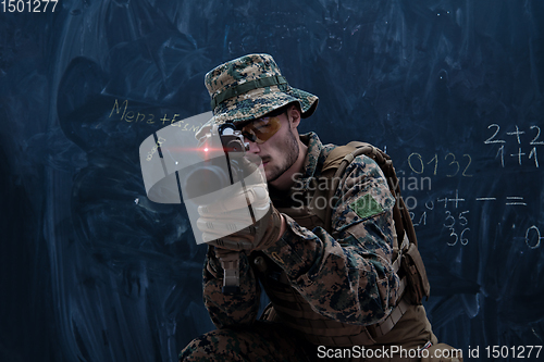Image of soldier in action aiming laseer sight optics