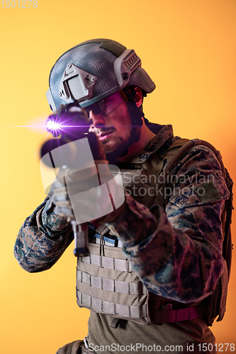 Image of soldier in action aiming laseer sight optics yellow background