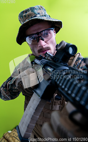 Image of soldier in action aiming laseer sight optics green background