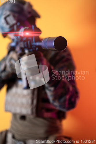 Image of soldier in action aiming laseer sight optics yellow background