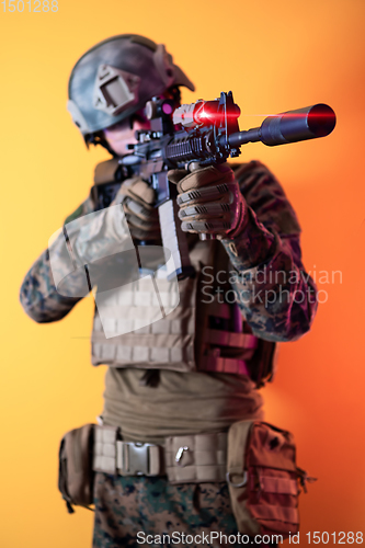 Image of soldier in action aiming laseer sight optics yellow background