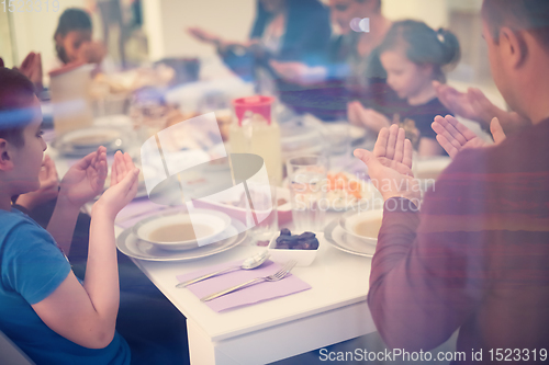 Image of Eid Mubarak  Islamic family praying before halal Iftar dinner