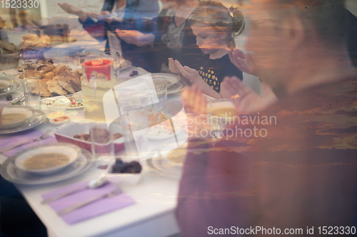 Image of Eid Mubarak  Islamic family praying before halal Iftar dinner