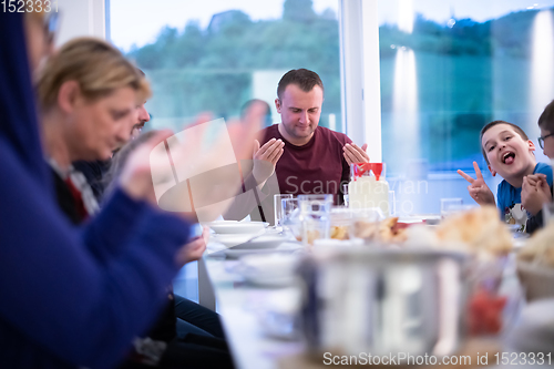 Image of Eid Mubarak  Islamic family praying before halal Iftar dinner