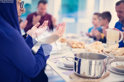 Image of Eid Mubarak  Islamic family praying before halal Iftar dinner