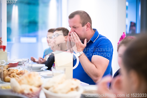 Image of Eid Mubarak  Islamic family praying before halal Iftar dinner