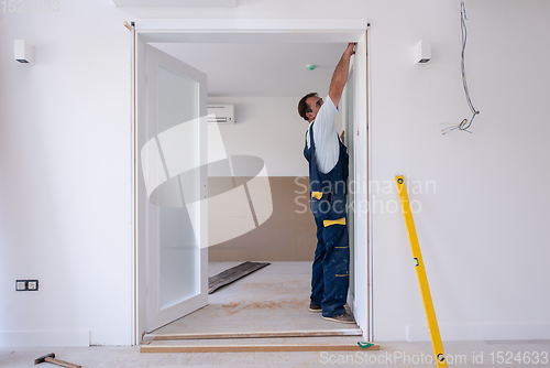 Image of carpenters installing glass door with a wooden frame