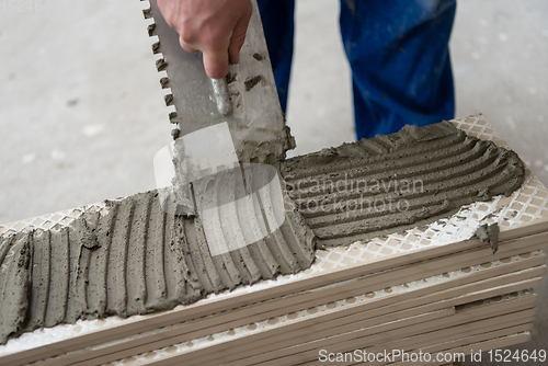 Image of worker installing the ceramic wood effect tiles on the floor