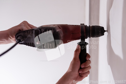 Image of construction worker drilling holes in the bathroom