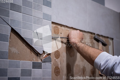 Image of worker remove demolish old tiles in a bathroom