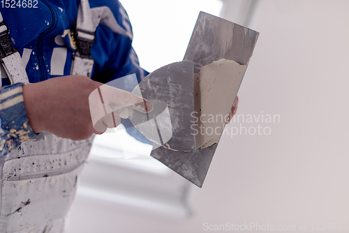 Image of construction worker plastering on gypsum walls