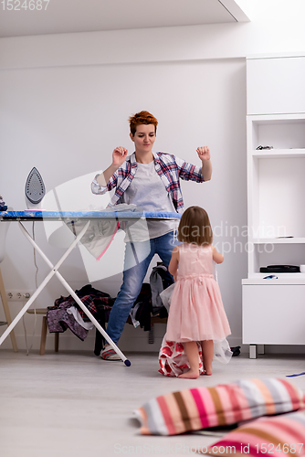 Image of mother and little daughter spending time together at home