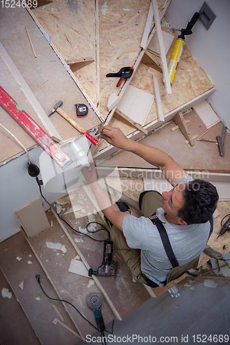 Image of carpenter installing wooden stairs