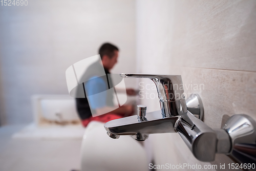 Image of professional plumber working in a bathroom