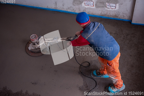 Image of worker performing and polishing sand and cement screed floor