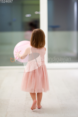 Image of cute little girl playing with balloons