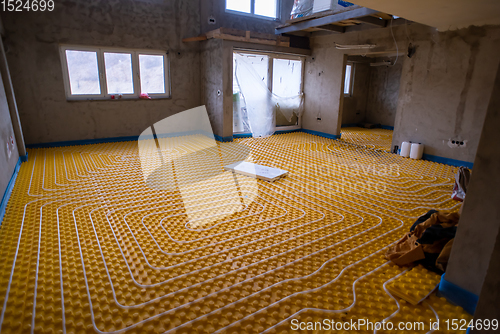 Image of yellow underfloor heating installation with white pipes