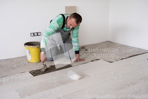 Image of worker installing the ceramic wood effect tiles on the floor