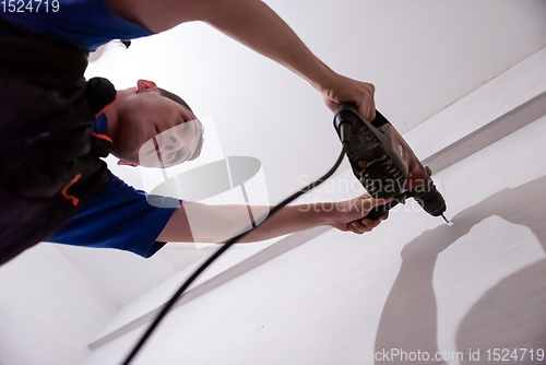 Image of construction worker drilling holes in the bathroom