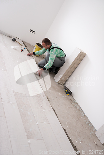 Image of worker installing the ceramic wood effect tiles on the floor