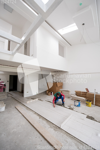 Image of worker installing the ceramic wood effect tiles on the floor