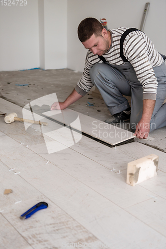 Image of worker installing the ceramic wood effect tiles on the floor