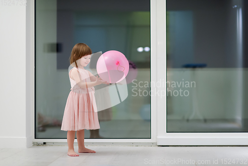 Image of cute little girl playing with balloons